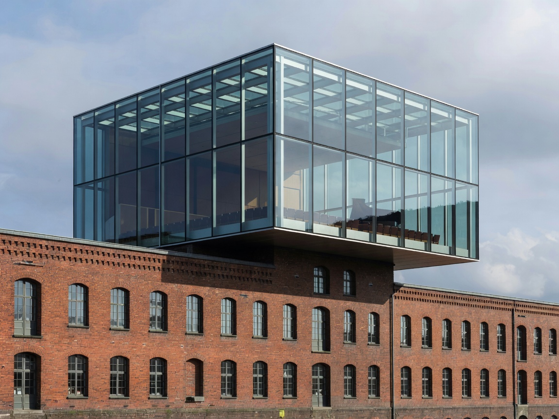 Modernist glass concert hall perched on top of red brick historic warehouse in Hamburg